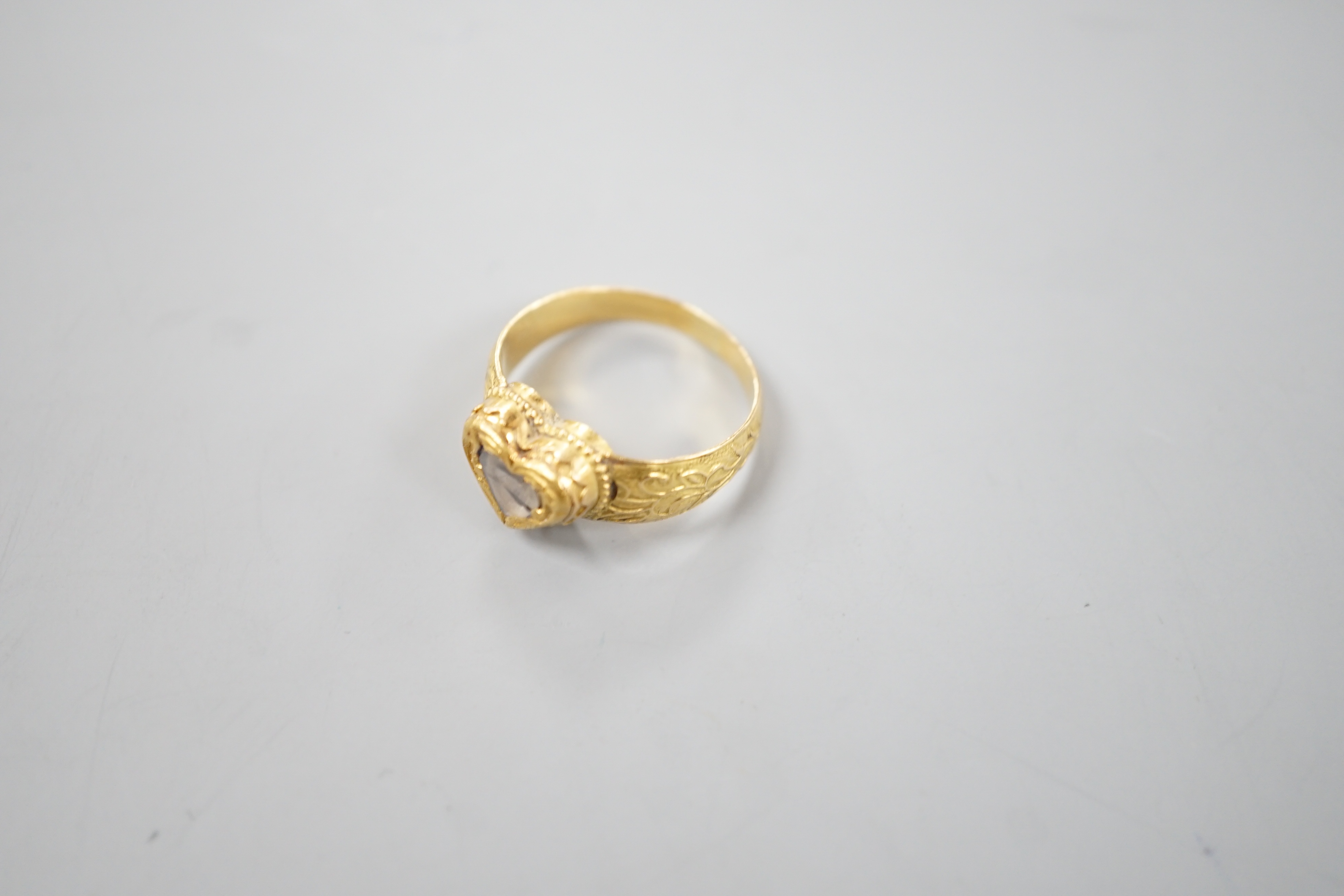An Indian yellow metal and heart shaped diamond set ring, with engraved shank, size O, gross weight 6.2 grams, (crack to stone).